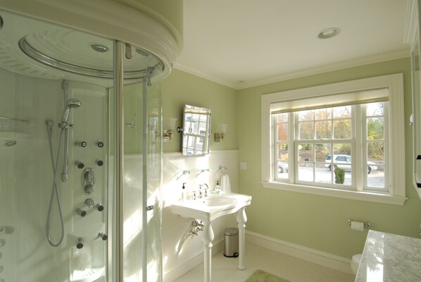 A bathroom with a glass-enclosed shower, a white sink, and a window with a view of the outside. - LUXURY BEACHFRONT ESTATE - Private Heated Pool (York Harbor)
