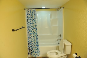 Bathroom features a bathtub and toilet in a simple, functional design.