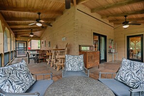 Un interior de madera espacioso con techo alto, varias zonas de estar y ventiladores de techo.