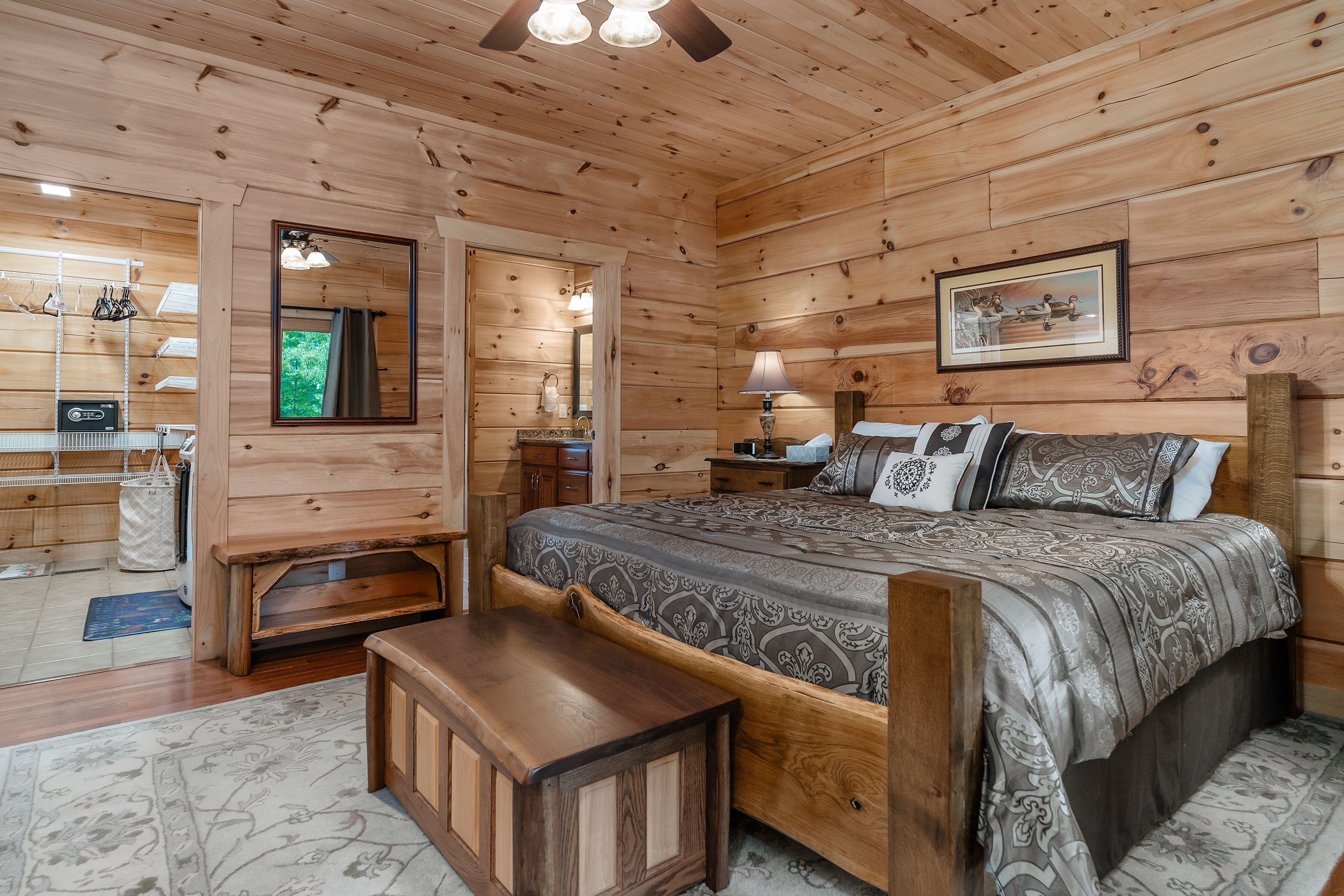 Une chambre dans une cabane en bois, avec un lit, des tables de chevet, un miroir et une commode.