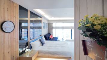 Relax in a serene space with a large bed, wooden accent wall, and natural light pouring in through the large window.