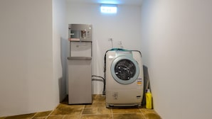 A laundry room with a washing machine and a refrigerator. - Color Fun Inn (Kaohsiung)