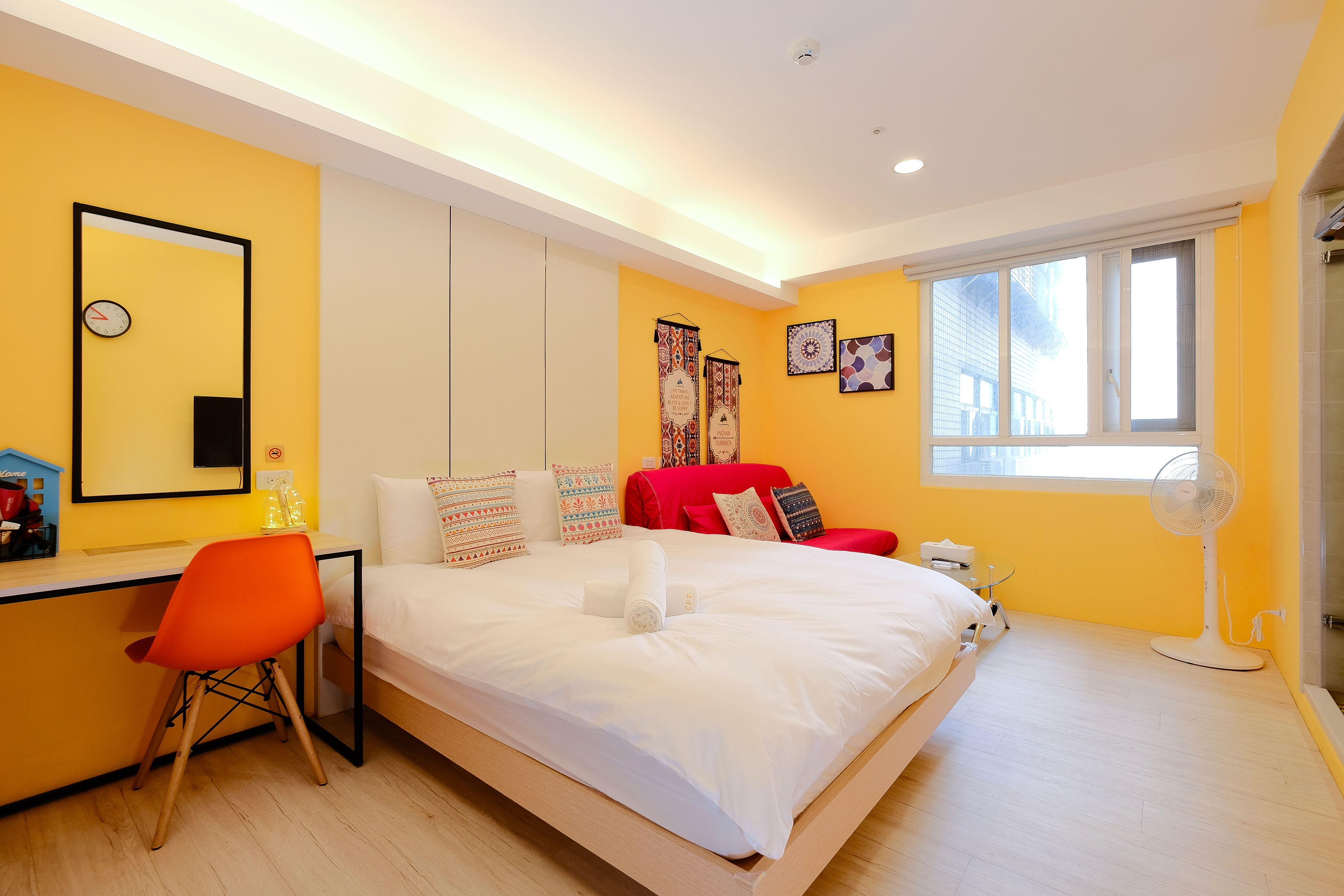 A modern bedroom with a bed, a desk, and a chair.