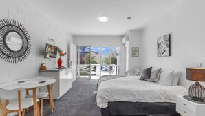 Ein modernes Schlafzimmer mit Bett, Nachttisch und Schreibtisch mit Stühlen.