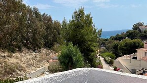 A balcony with a table, chairs, a bottle of champagne, and a glass. - Casa Jomy, a beautiful place! Sea views! (Campello)