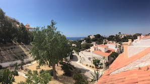 A coastal town with terracotta-roofed buildings, a clear blue sky, and a view of the sea. - Casa Jomy, a beautiful place! Sea views! (Campello)