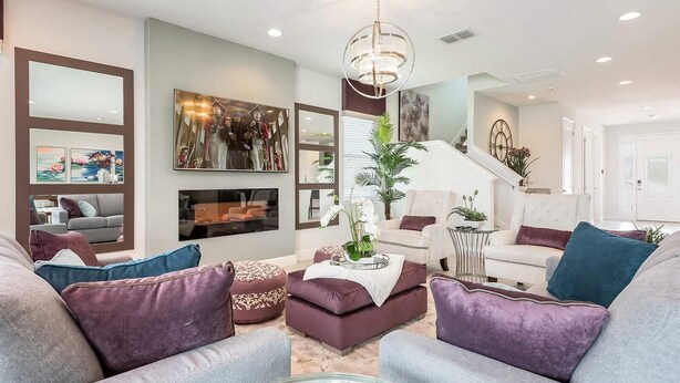 A modern living room with a fireplace, comfortable seating, and decorative artwork. - Spacious Villa with Home Theater at Encore (Kissimmee)