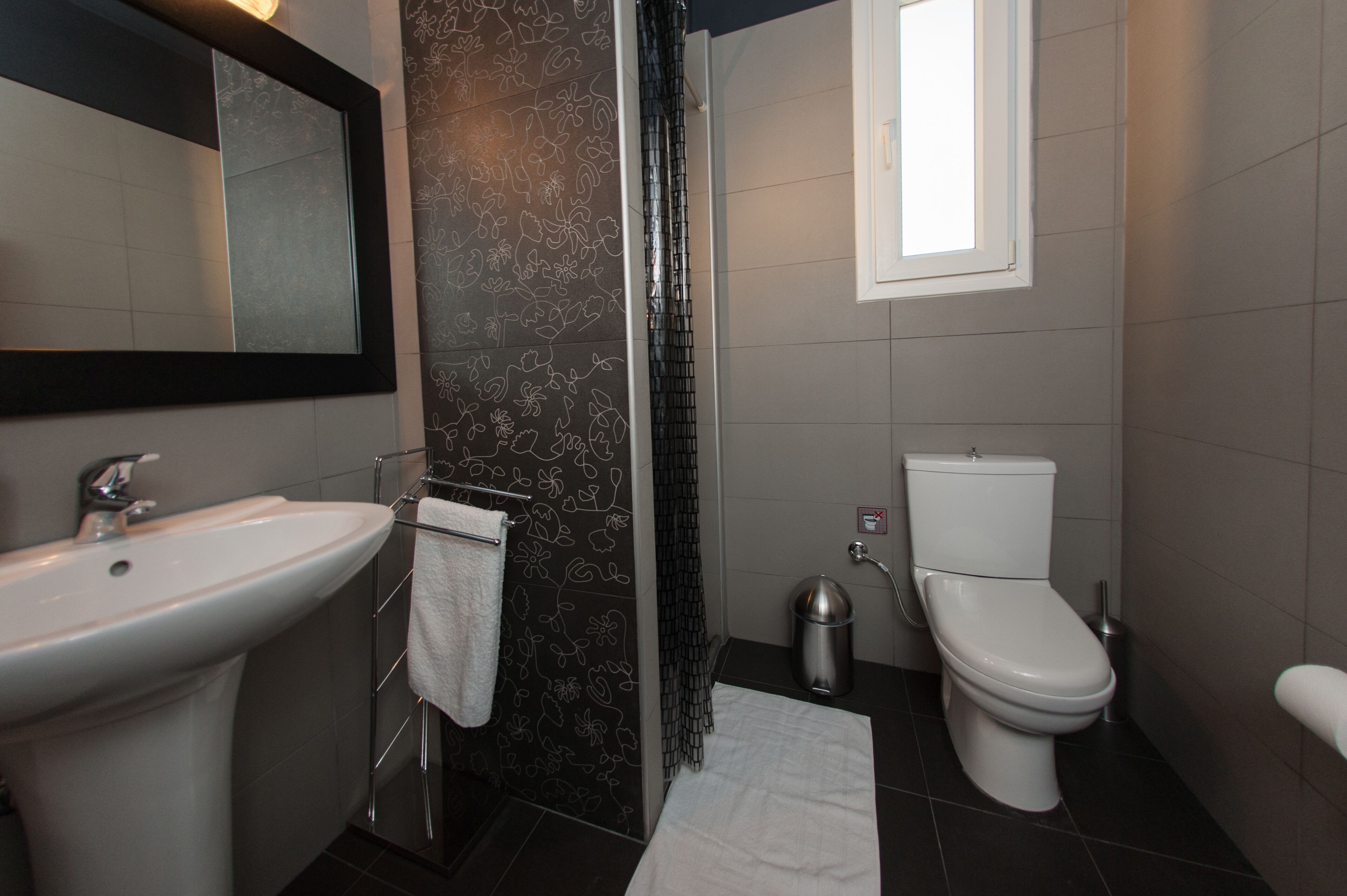 A modern bathroom with a sink, toilet, and shower area.