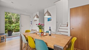 A modern dining area with a wooden table, colorful chairs, and pendant lights. - Beautiful holiday home, just a walk away from Talland beach... (Looe)