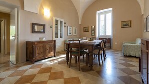 A dining area with a checkered floor, wooden furniture, and a window with natural light.