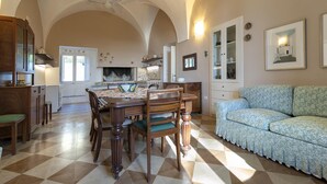 A spacious kitchen with a dining table, chairs, and a sofa.
