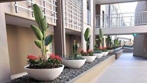 Un pasillo con plantas en macetas y piso de baldosas.
