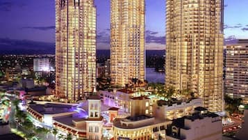 A high-rise hotel with multiple floors, a pool area, and a waterfront view.