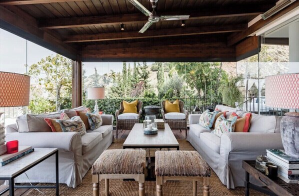 An outdoor seating area with two sofas, a coffee table, and a ceiling fan. - SEA, GOLF, RELAX, LANDSCAPE, POOL (Rincón de la Victoria)