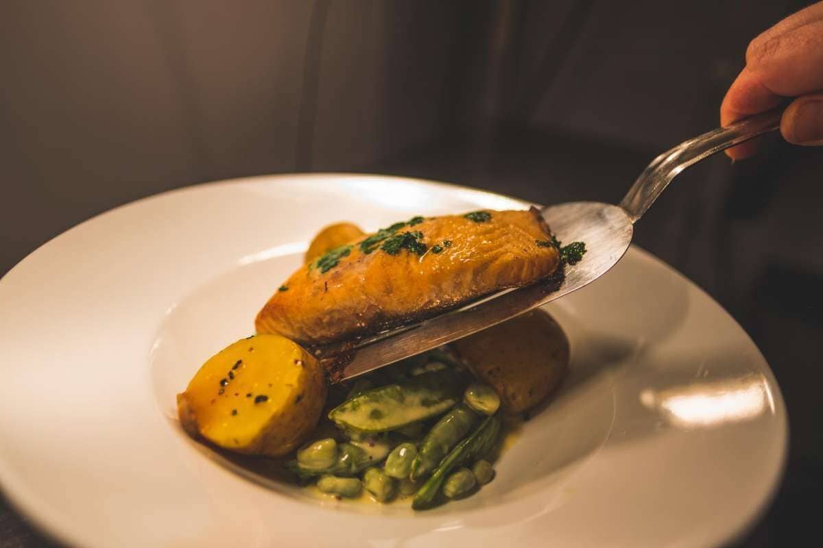 Ein Teller mit Lachs, Kartoffeln und grünen Bohnen.