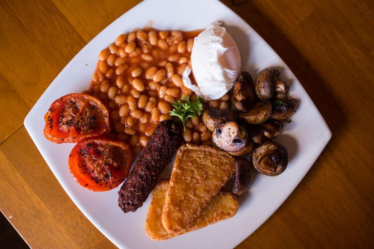 Plat de menjar amb fesols, bolets, botifarreta i tomàquets.