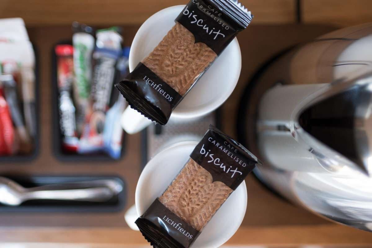 Deux paquets de biscuits portant l’étiquette « LICHFIELDS » sont posés sur des assiettes blanches.