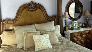 A bedroom with a large bed, a wooden headboard, a nightstand with a lamp, and a mirror. - CASA COLONIAL PLAYAS  CHAPULTEPEC DOS CUADRAS DE LA PLAYA GRANDE PARKING ADENTRO (Colonia Playas de Chapultepec Ensenada)