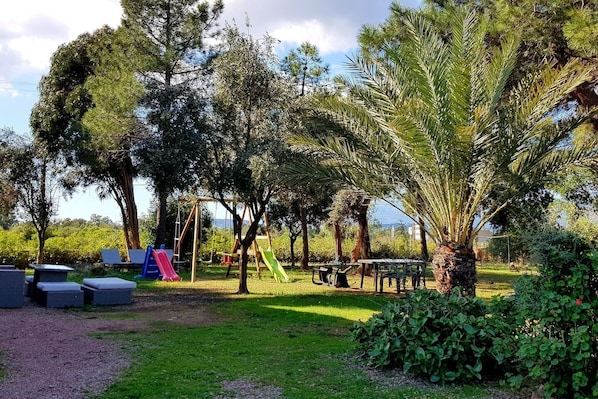 A park with a playground, seating areas, and a picnic table.