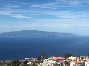 A coastal town with buildings and a mountain in the background. - Casa Victoria Sunny Terrace & Teide Views (Adeje)