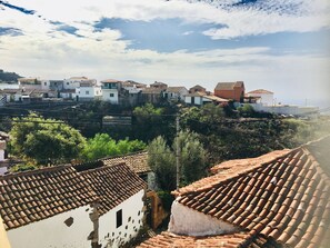 A coastal village with terracotta-tiled rooftops, white buildings, and lush greenery. - Casa Victoria Sunny Terrace & Teide Views (Adeje)