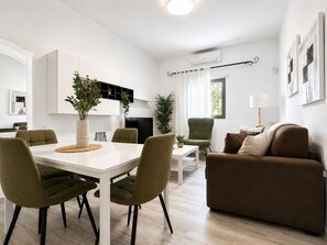 A modern living space with a dining area, a sofa, and a TV. - Casa Victoria Teide & Ocean Views Sunny Terrace (Adeje)