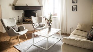 Ein Wohnzimmer mit zwei Sesseln, einem Sofa, einem Couchtisch und einem Kamin.