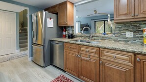 A modern kitchen with wooden cabinets, stainless steel appliances, and a granite countertop. - 10 Ocean Gate: 2BR, 2.5BA Community Pool, Short Walk to Beach, Free Bikes (Hilton Head Island)