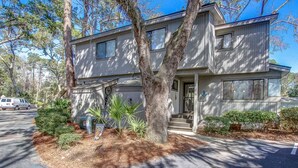 A two-story residential building with a front porch, a driveway, and a parking area. - 10 Ocean Gate: 2BR, 2.5BA Community Pool, Short Walk to Beach, Free Bikes (Hilton Head Island)