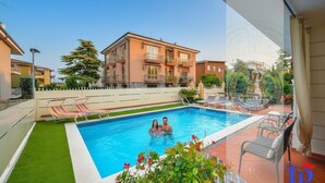 A residential building with a swimming pool, a fenced yard, and a balcony. - Desenzanoloft Garden and Pool (Desenzano del Garda)