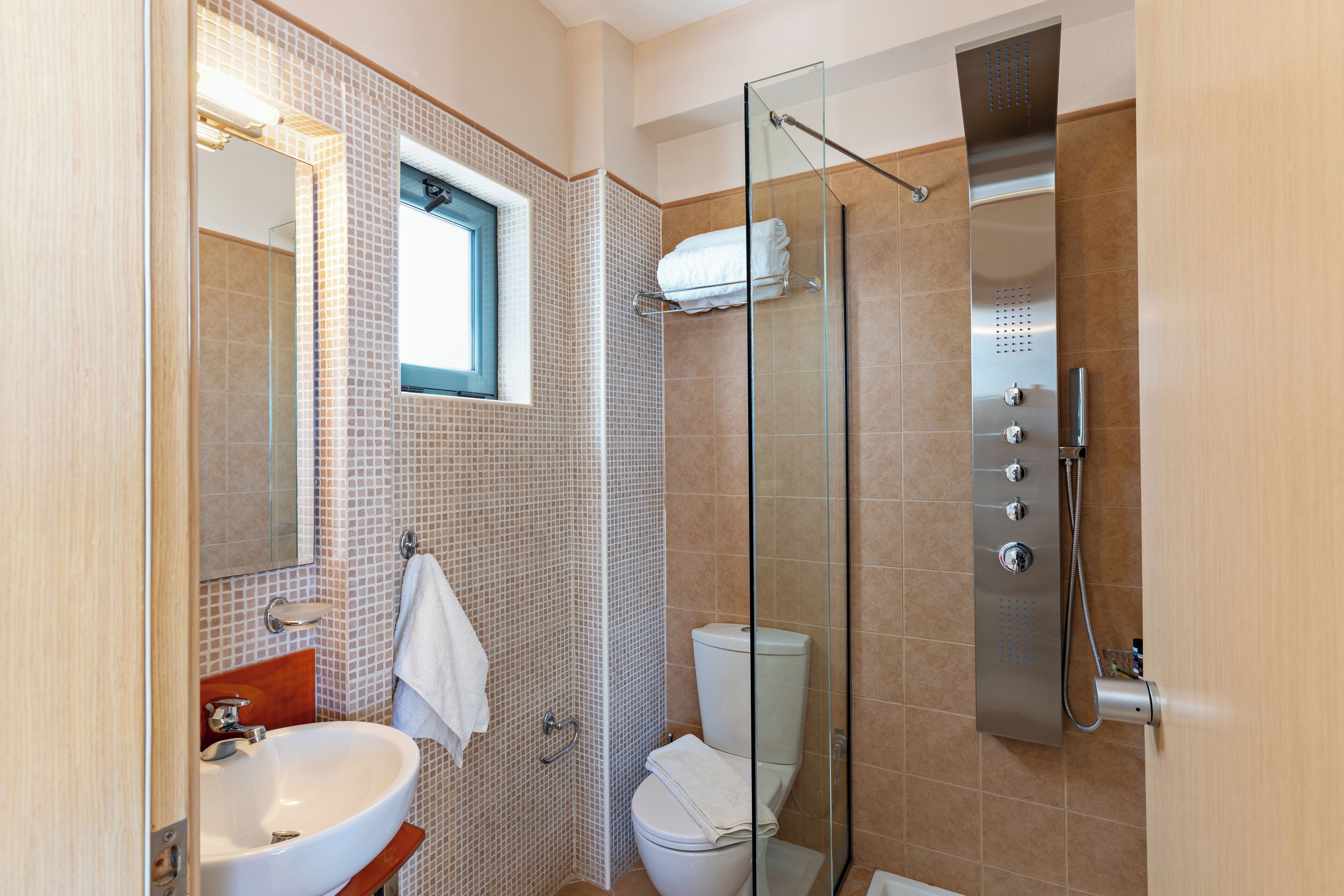 Ein modernes Badezimmer mit einer Duschkabine aus Glas, einem weißen Waschbecken und einer Toilette.