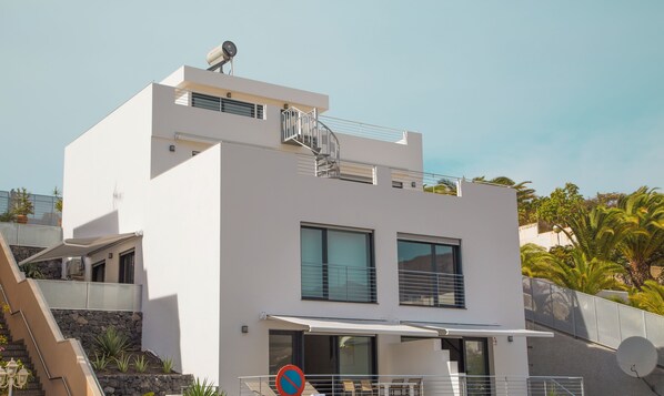 Un bâtiment moderne à deux étages, doté d’un toit plat, de grandes fenêtres et d’une antenne parabolique.