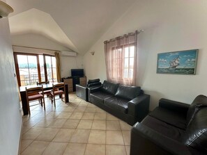 Appartement Confort, 1 grand lit et 1 canapé-lit, vue partielle sur la mer | Coin séjour