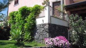 Un bâtiment rose avec un mur en pierre et un balcon.