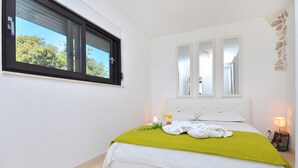 A bedroom with a large bed, a window, and a nightstand with a lamp. - Luxury Villa In Split, Few Minutes To Center, Beaches, Shopping, Sport Courts (Split)