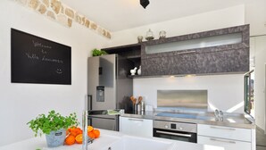 A modern kitchen with a white countertop, stainless steel appliances, and a blackboard sign. - Luxury Villa In Split, Few Minutes To Center, Beaches, Shopping, Sport Courts (Split)