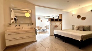 A bedroom with a bed, a dresser, a mirror, and a chair.