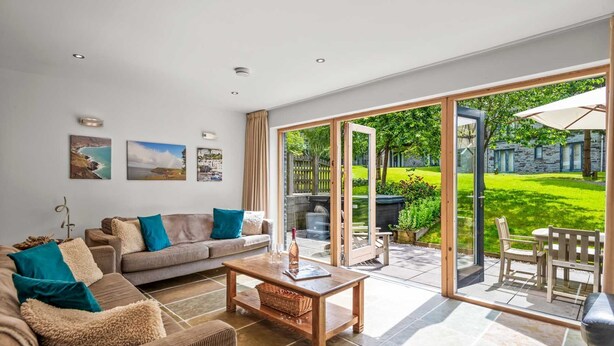 A modern living room with a large sliding glass door leading to a patio.