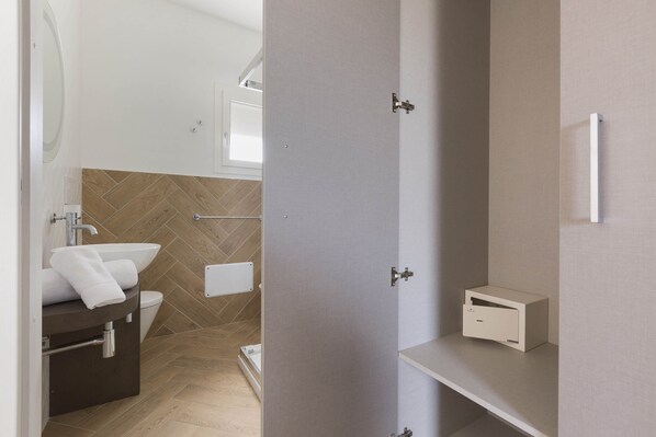 A modern bathroom with a white sink, a toilet, and a towel rack.