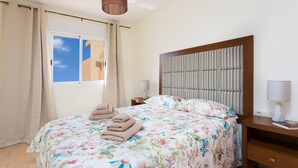 A hotel room with a bed, a nightstand, a lamp, and a window with curtains. - Adeje with pool, sea view and WIFI gratis (Adeje)