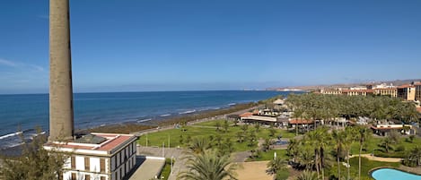 A coastal resort with a prominent lighthouse, a swimming pool, and a beachfront area.