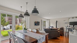 Eine moderne Küche mit Essbereich, einer Couch und einem Fernseher.