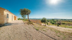 A rural property with a gravel driveway leading to a building with a tiled roof and a tree in the foreground. - Nice home in Badesi OT with house sea view (Badesi OT)