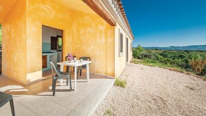 A yellow building with a patio, a table, and chairs. - Nice home in Badesi OT with house sea view (Badesi OT)