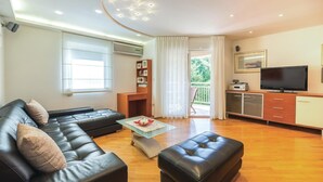Een moderne woonkamer met een leren bank, een glazen salontafel en een televisie.