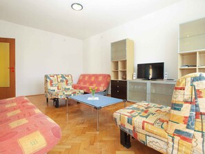 A living room with a sofa, armchairs, a table, a television, and a cabinet. - Holiday apartment mit Terrasse und Klimaanlage (Ližnjan)
