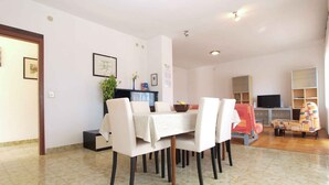 Un coin repas avec une table et des chaises, un téléviseur et une bibliothèque.