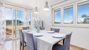 Comedor con una mesa para cuatro, ventanas amplias y vistas al exterior.
