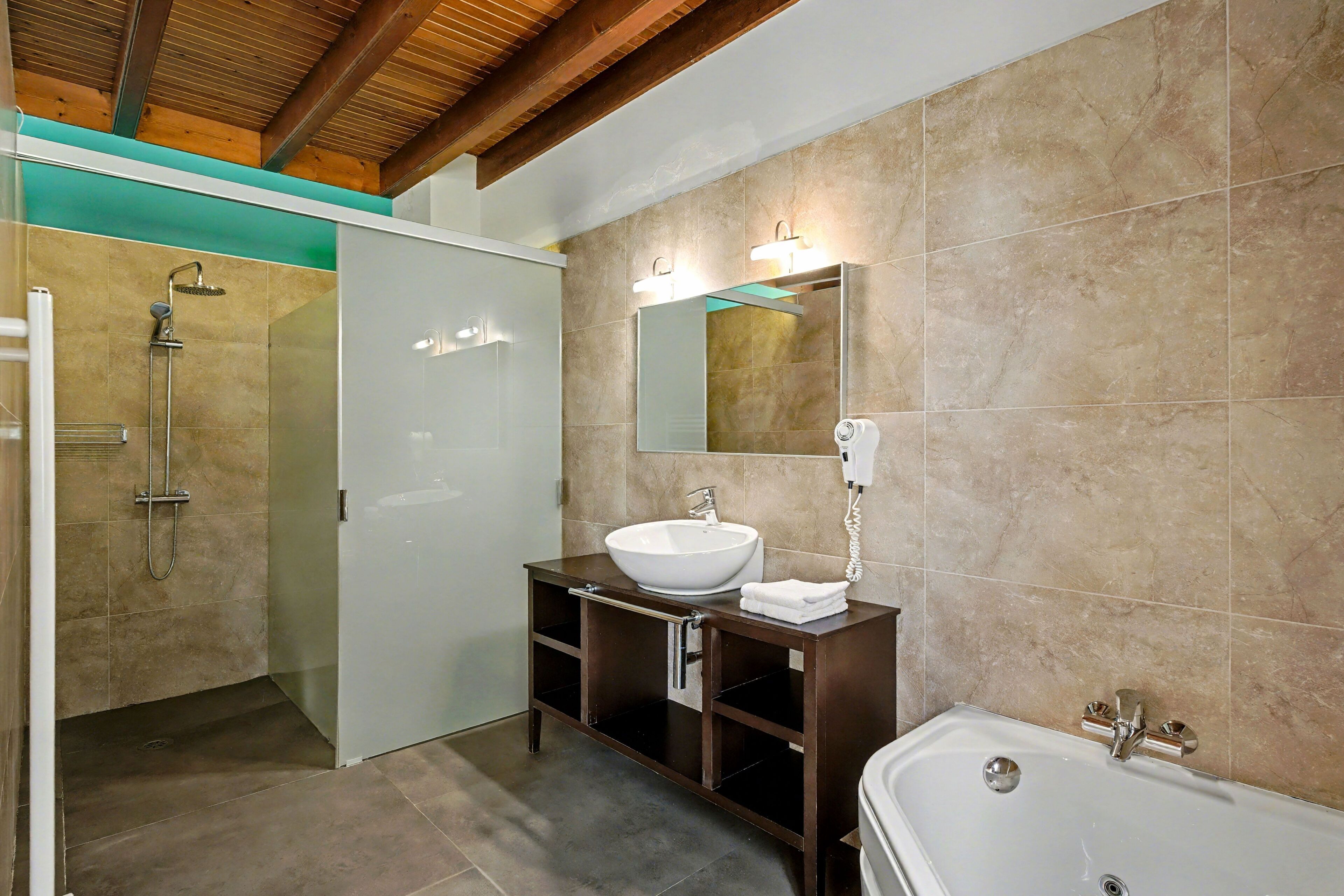 A modern bathroom with a large sink, a bathtub, and a shower area.