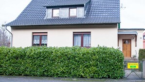 A two-story house with a sloped roof, a small attic window, and a front door with a sign indicating 'free' accommodation. - Apartment Sandra Mattaj (Blankenburg (Harz))